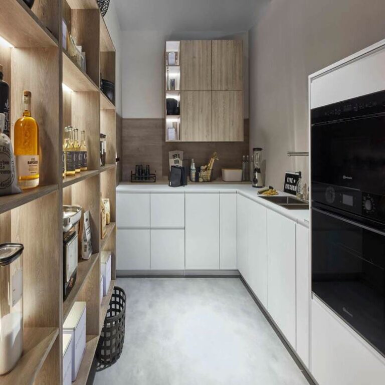 Moderne weiße Küche mit Hochschränken, Holzregal und schwarzen Einbaugeräten – Küchenangebote Bonn